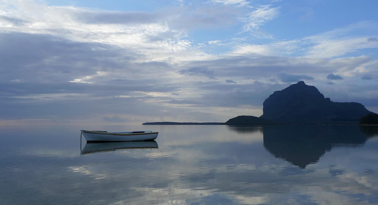 A small boat on still water below Le Morne Brabant, Mauritius