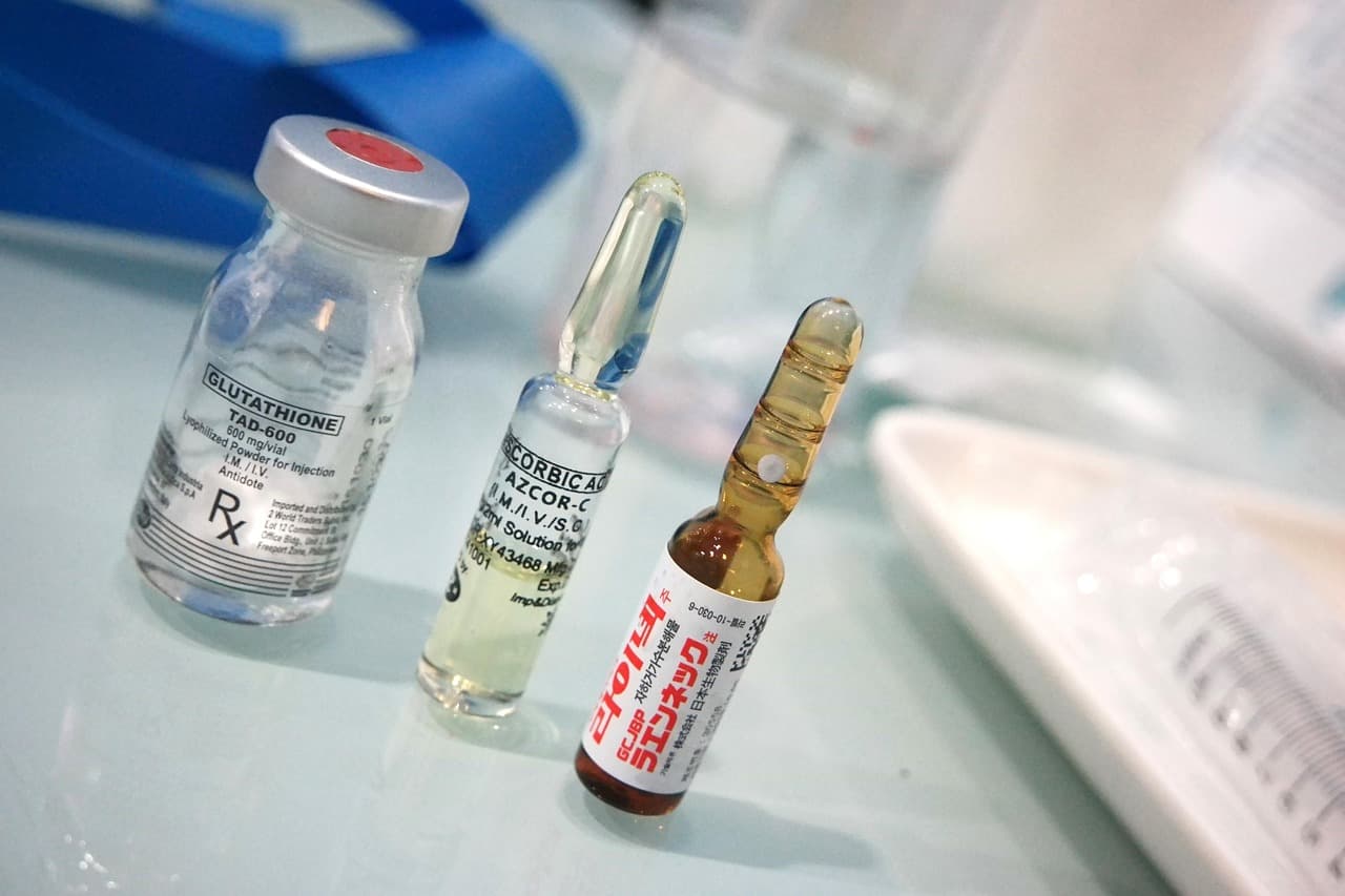 A medicine vial and two glass ampoules on a table